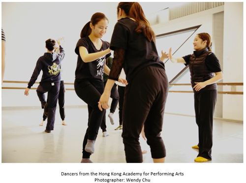 A group of dancers warming up in pairs